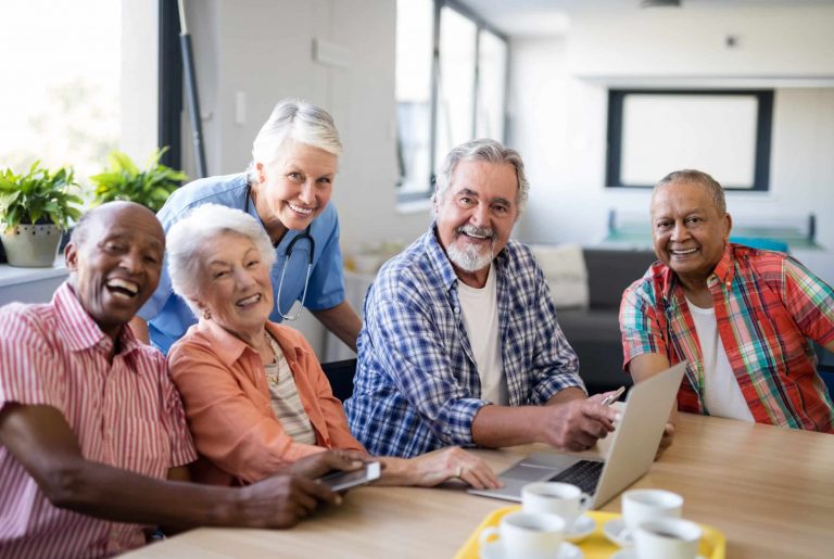 Portrait,Of,Smiling,Practitioner,With,Senior,People,By,Table,At